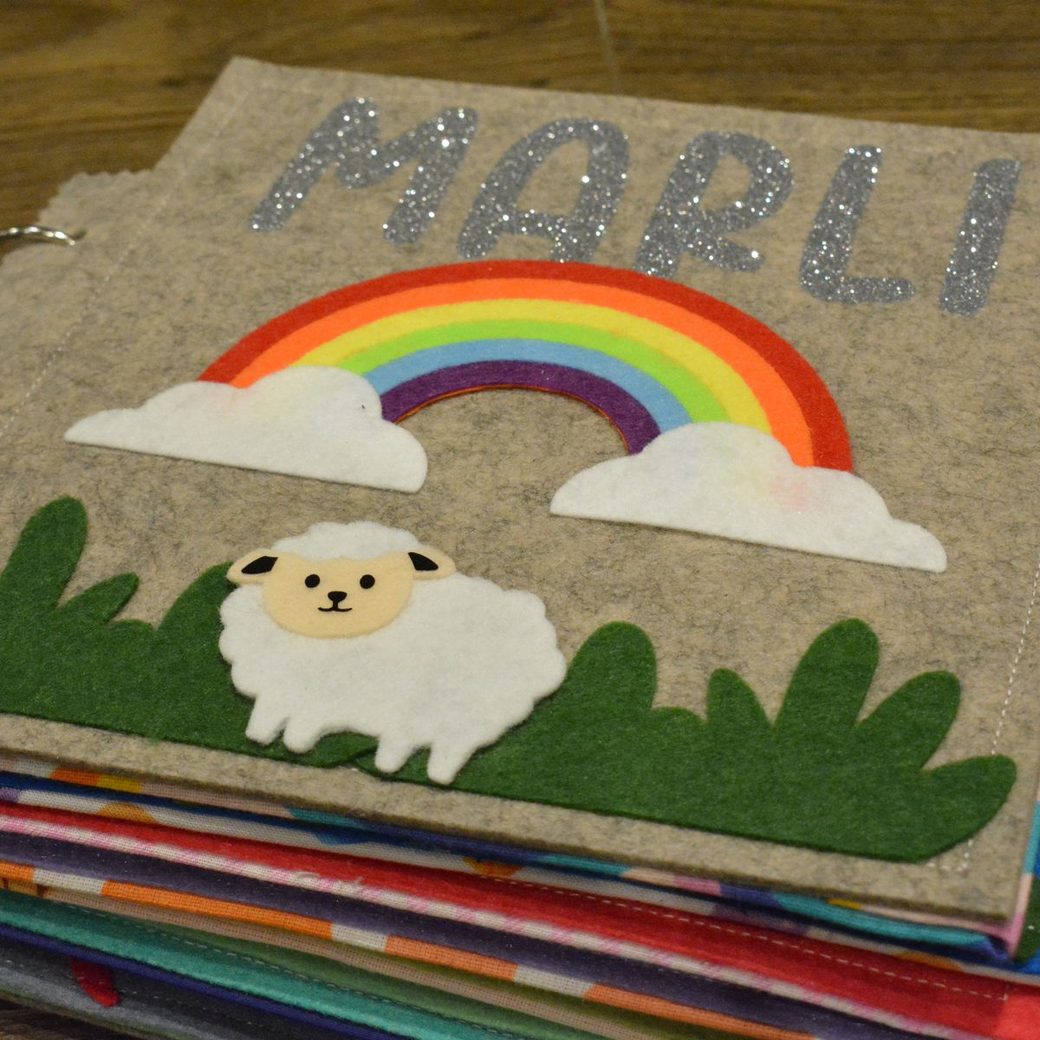A rainbow cover with a sheep in the grass, made for one child.